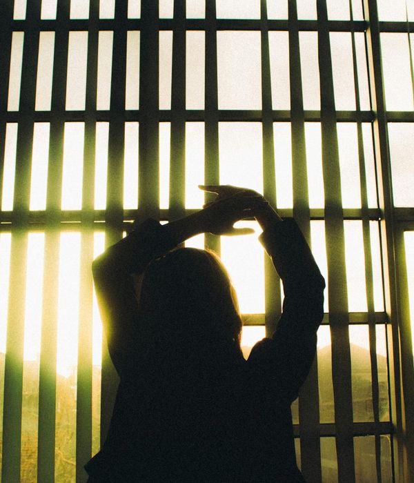 Woman in a peaceful yoga pose during sunrise with warm light.